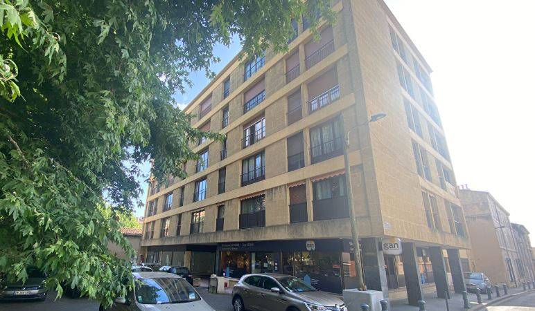 la façade de l'immeuble vue sur le parking de la copropriété