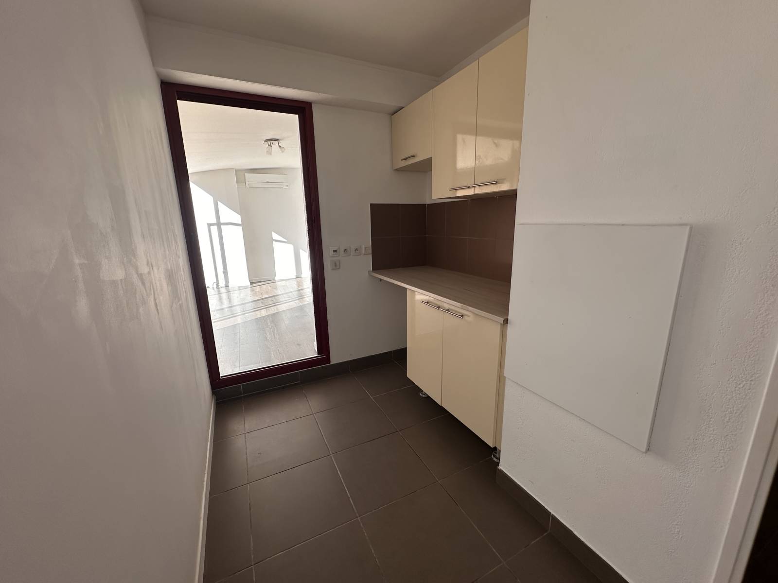 la buanderie dans laquelkle on retrouve des rangements et le branchement machine à laver