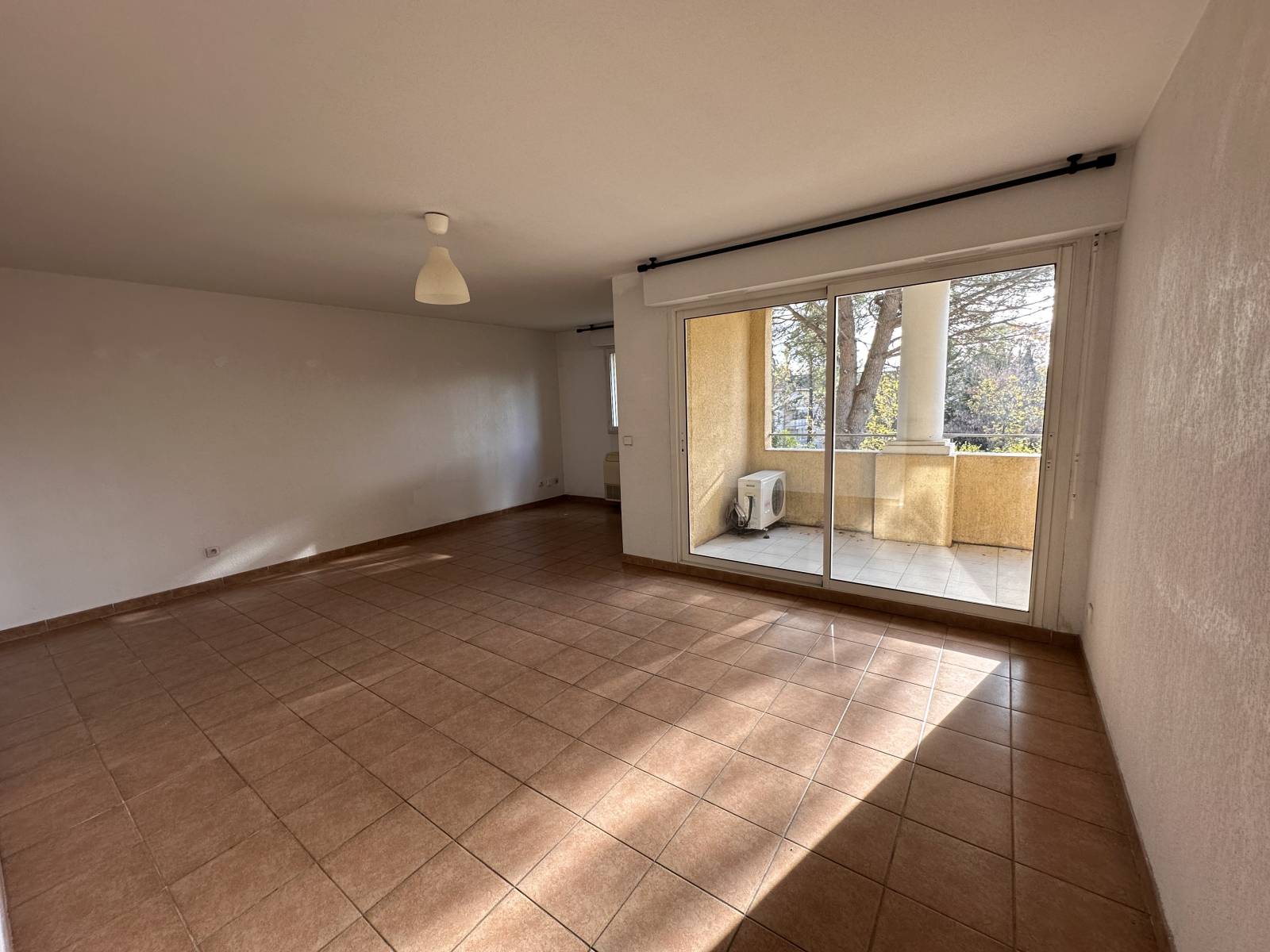 le séjour avec grande baie vitrée donnant sur terrasse plein sud