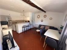 Le séjour avec le comptoir de la cuisine aménagée